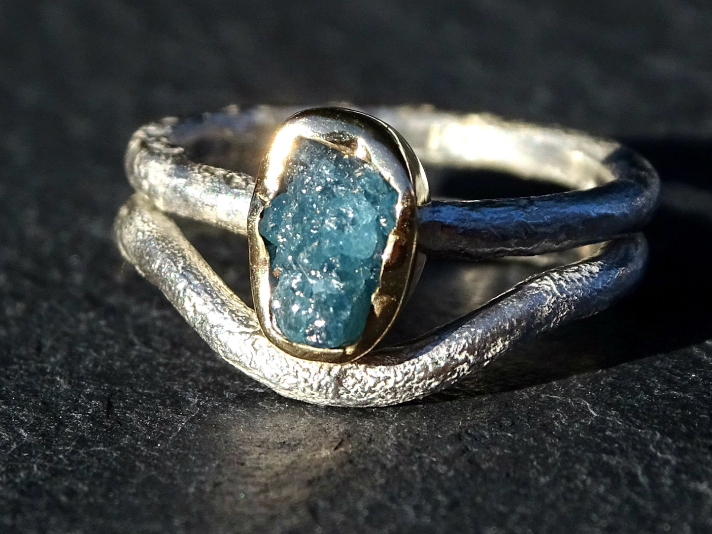 Raw blue diamond ring with gold bezel and textured silver band, unique engagement ring design