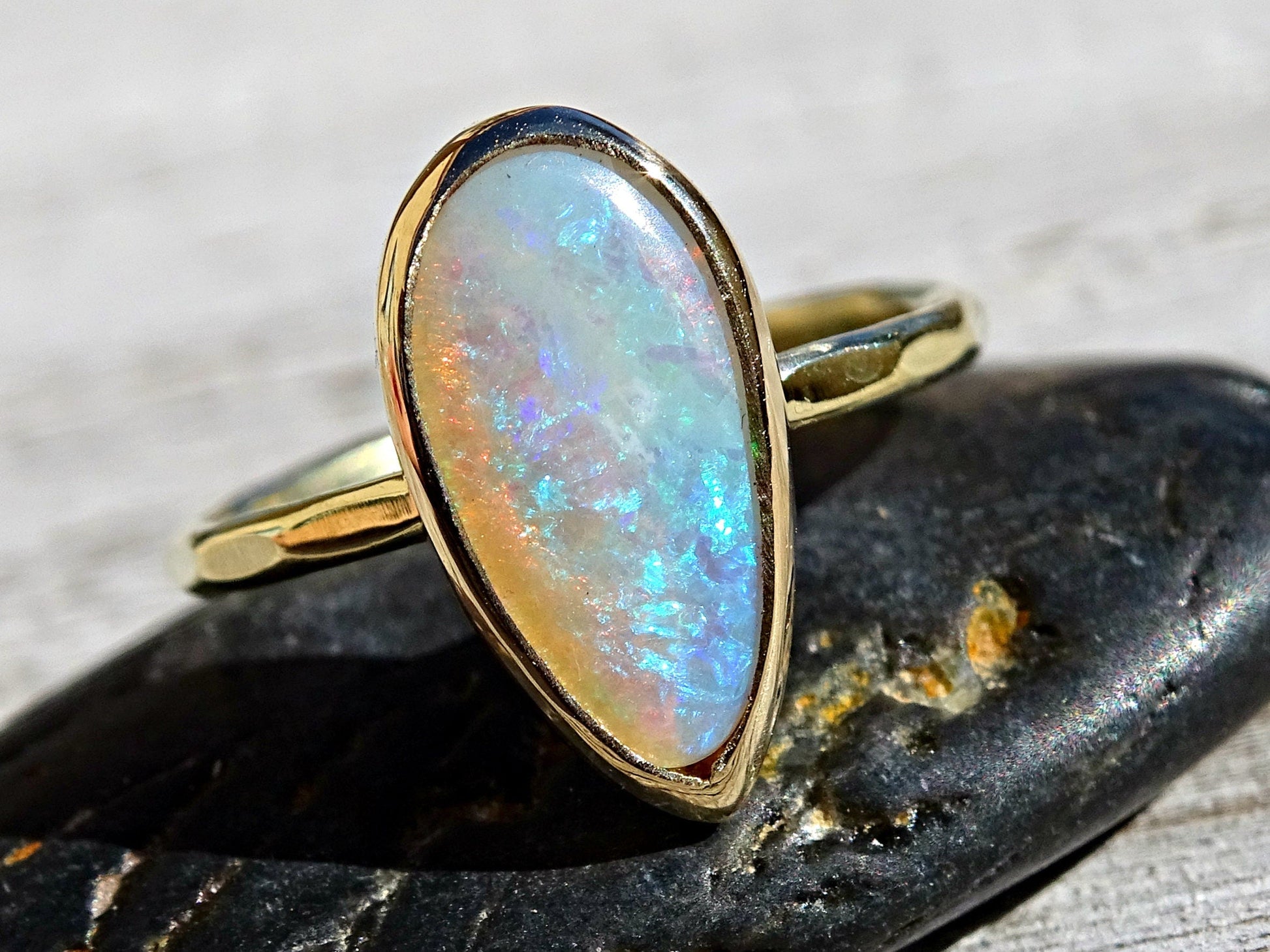 14k gold opal ring with hammered band and pear-shaped Australian crystal opal gemstone