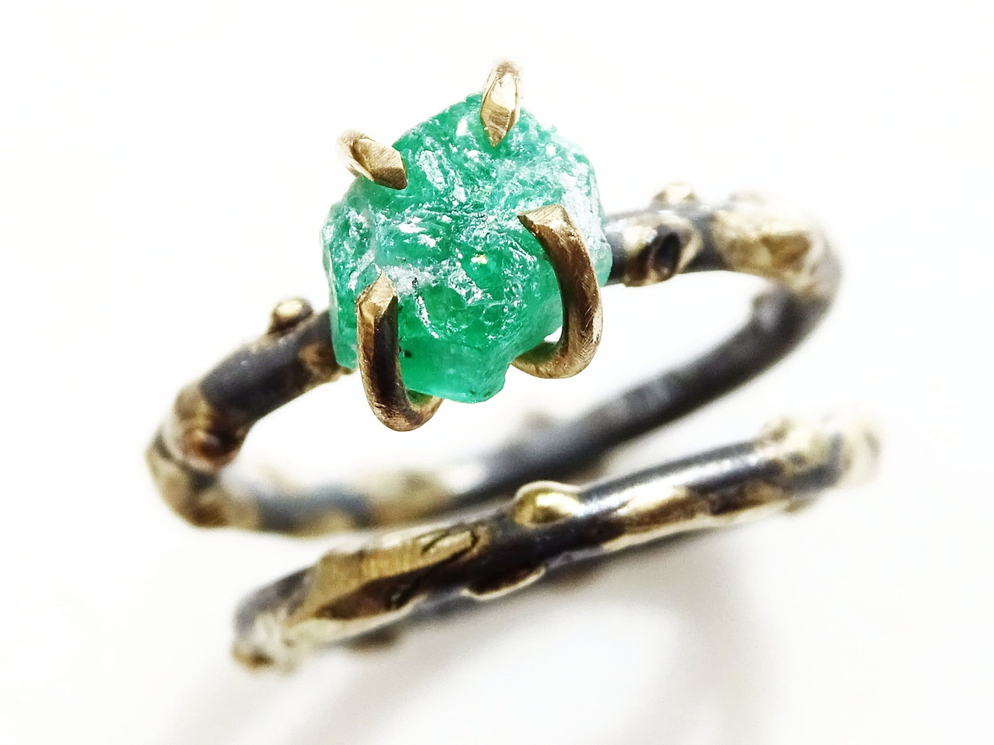 Raw emerald ring set with 14k gold prongs and dark oxidized silver bands, unique viking-style design