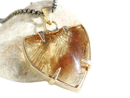 carved Oregon sunstone pendant with 28 carats set in 14k yellow gold on black sterling silver chain