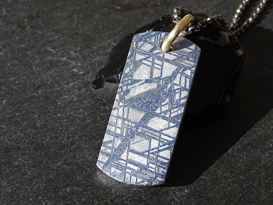 etched meteorite slice pendant with 14k gold bail showing Widmanstätten pattern on black background