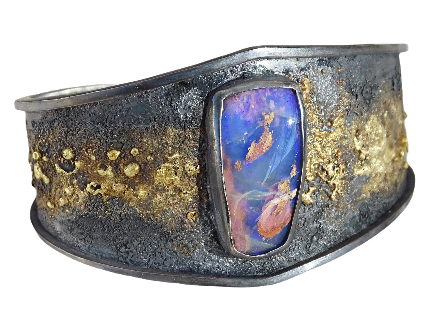 Close-up of a handmade purple Australian opal bracelet set in dark oxidized sterling silver with molten 14k gold accents.