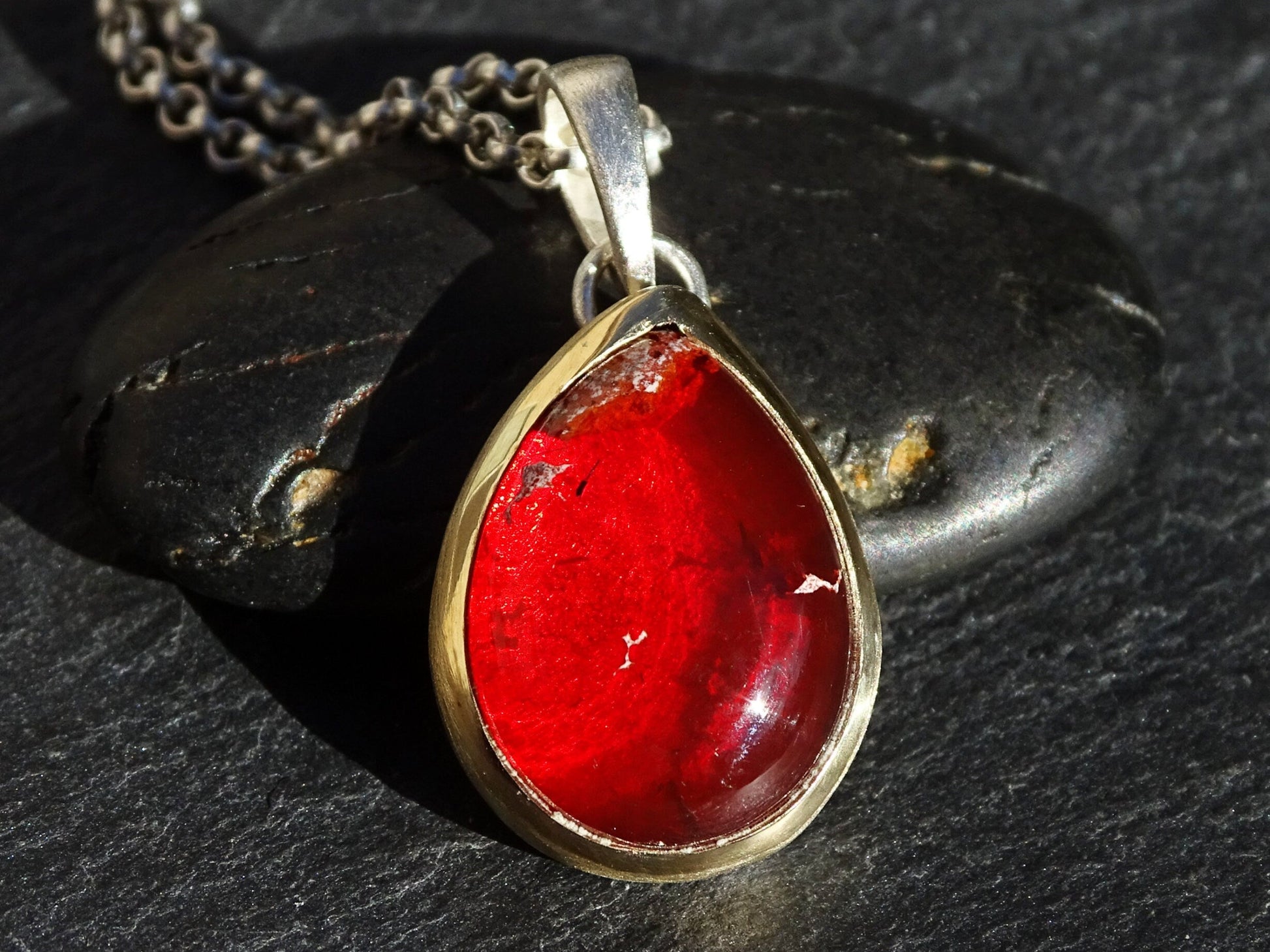 Red fire opal pear-shaped pendant set in 14k gold bezel with sterling silver bail and chain