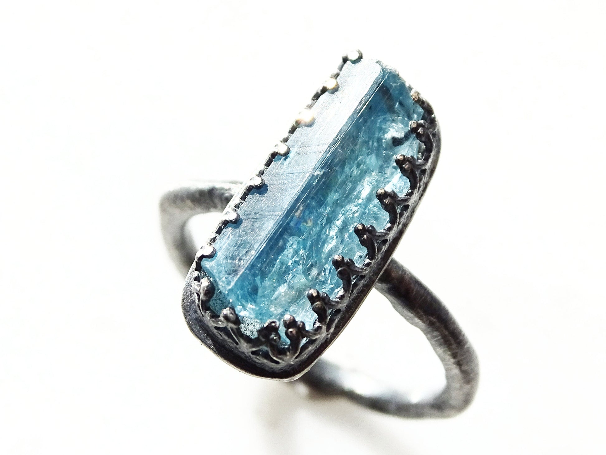 dark silver aquamarine ring with raw faceted blue crystal and crown bezel setting