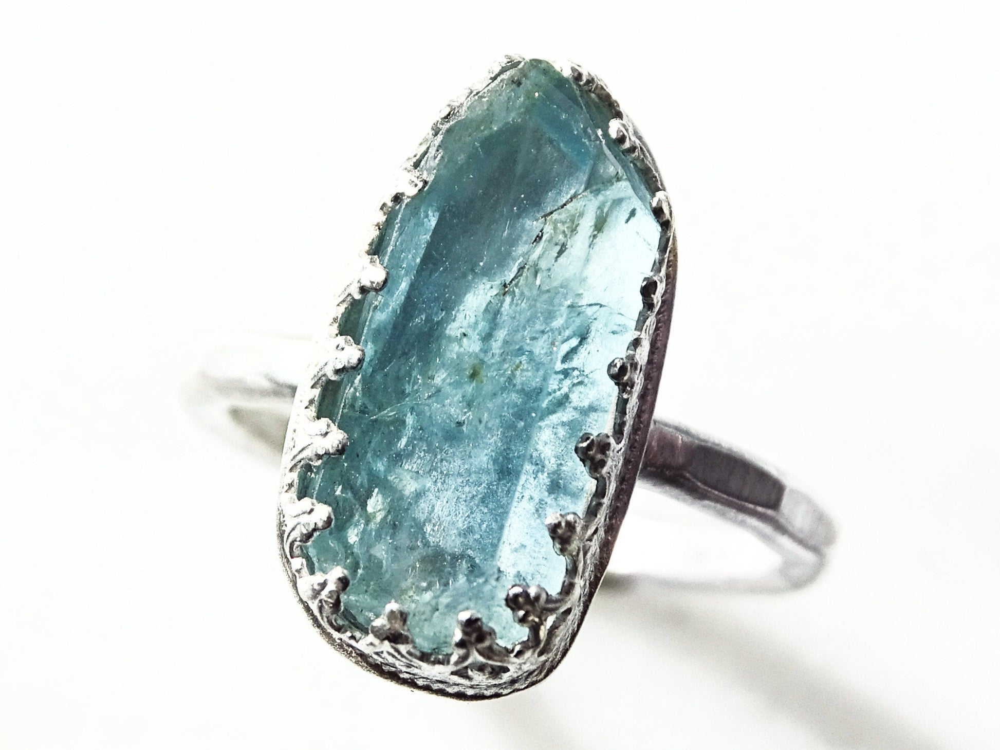 Dainty raw aquamarine ring with a rough blue crystal set in hammered sterling silver band