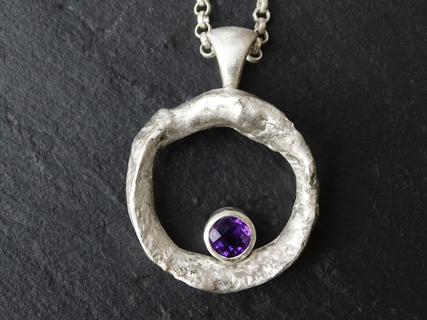 silver amethyst necklace with molten silver circle pendant and faceted purple gemstone