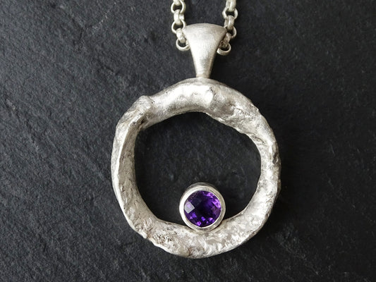 silver amethyst necklace with molten silver circle pendant and faceted purple gemstone