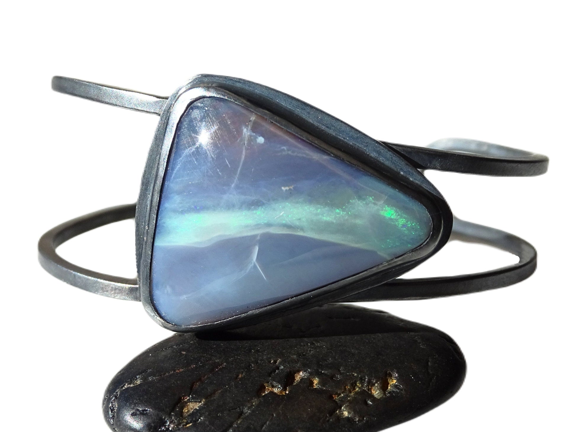 semi-black Australian opal bracelet in black sterling silver cuff with triangular lavender and green opal stone