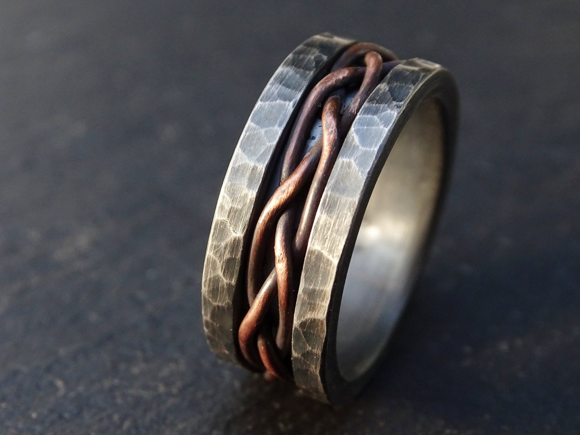 Dark silver braided men's wedding ring with hand woven copper inlay and hammered sterling silver sides