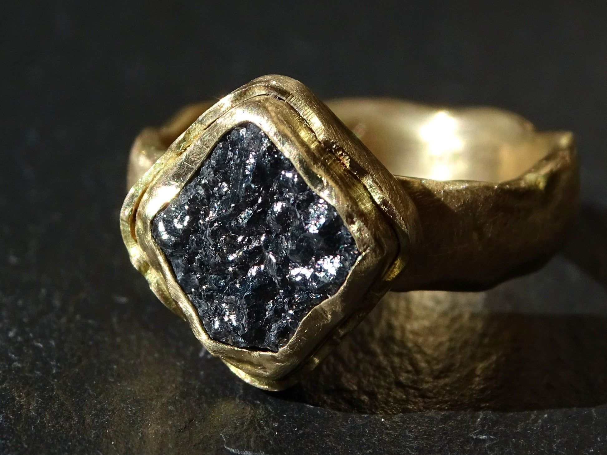14k gold diamond ring with large raw black square diamond and molten textured band