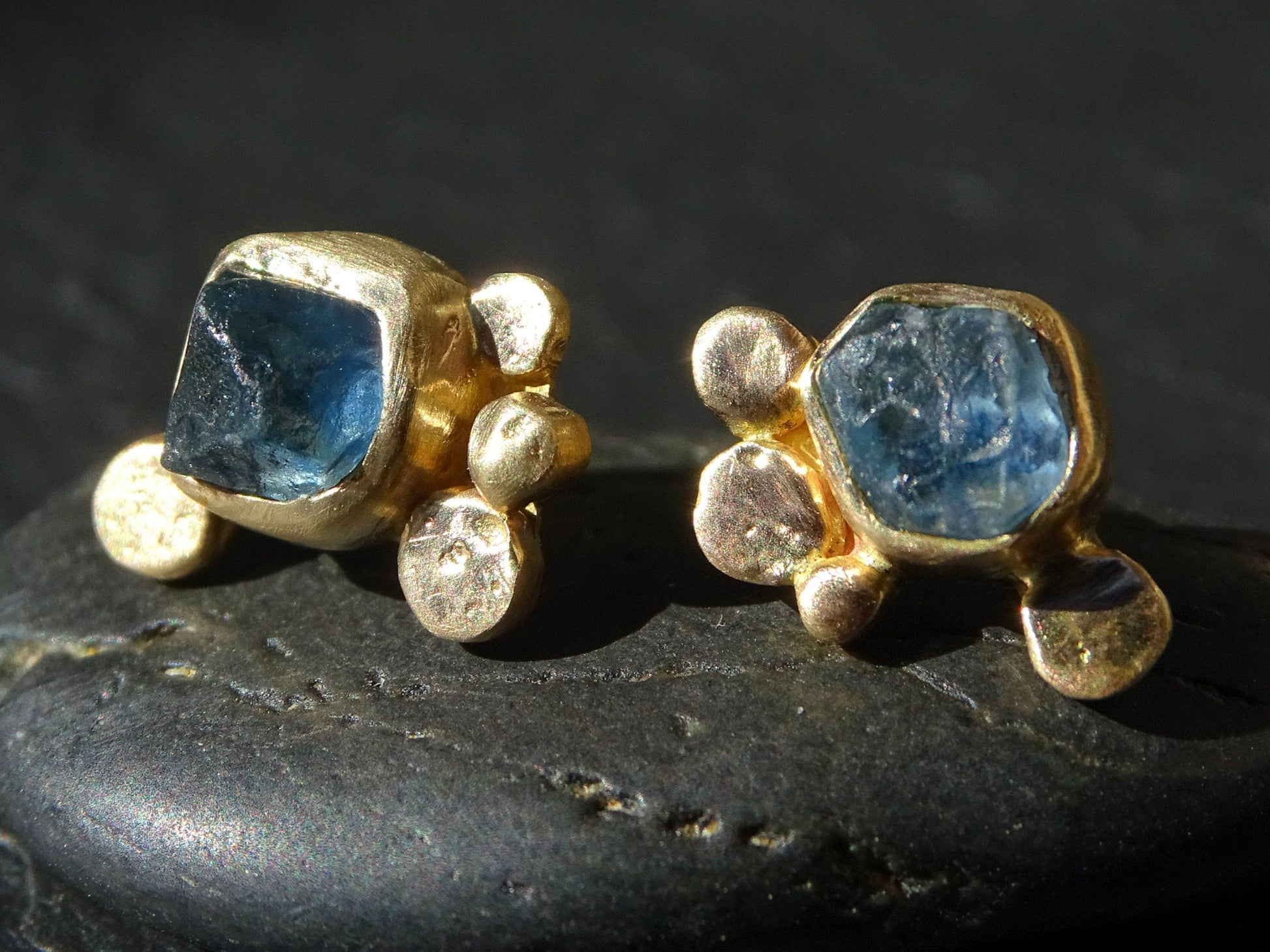 Handmade 14k gold stud earrings with raw blue sapphire gemstones and organic gold granule design