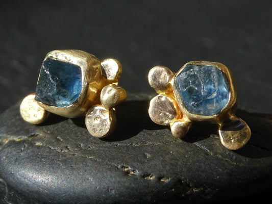 Handmade 14k gold stud earrings with raw blue sapphire gemstones and organic gold granule design