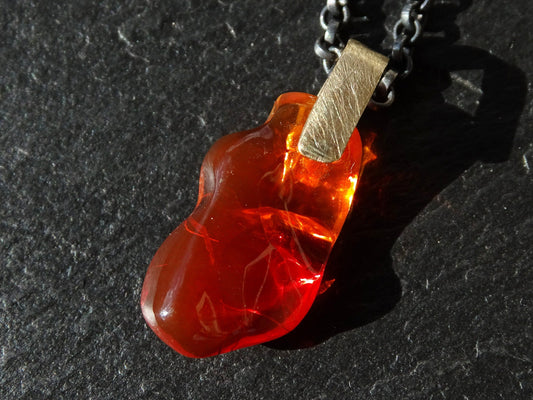 carved red fire opal pendant with solid 14k gold bail on black sterling silver chain