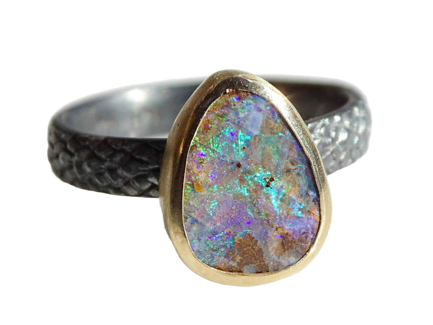 Black sterling silver opal ring with Australian boulder opal set in 14k gold bezel, featuring vibrant color play and textured band