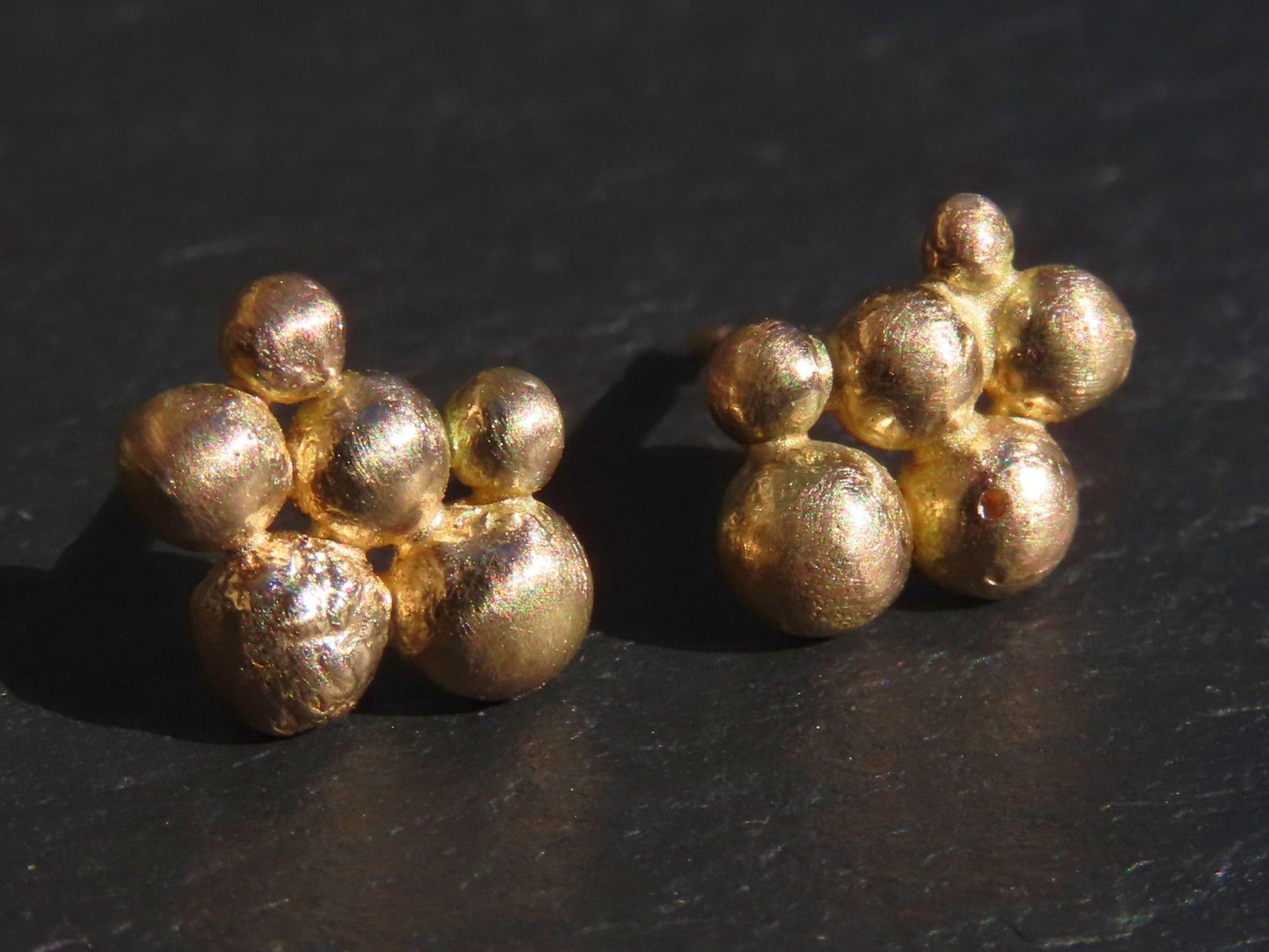 Minimalist solid 14k gold stud earrings with six textured gold beads in varying sizes, handmade and hypoallergenic.