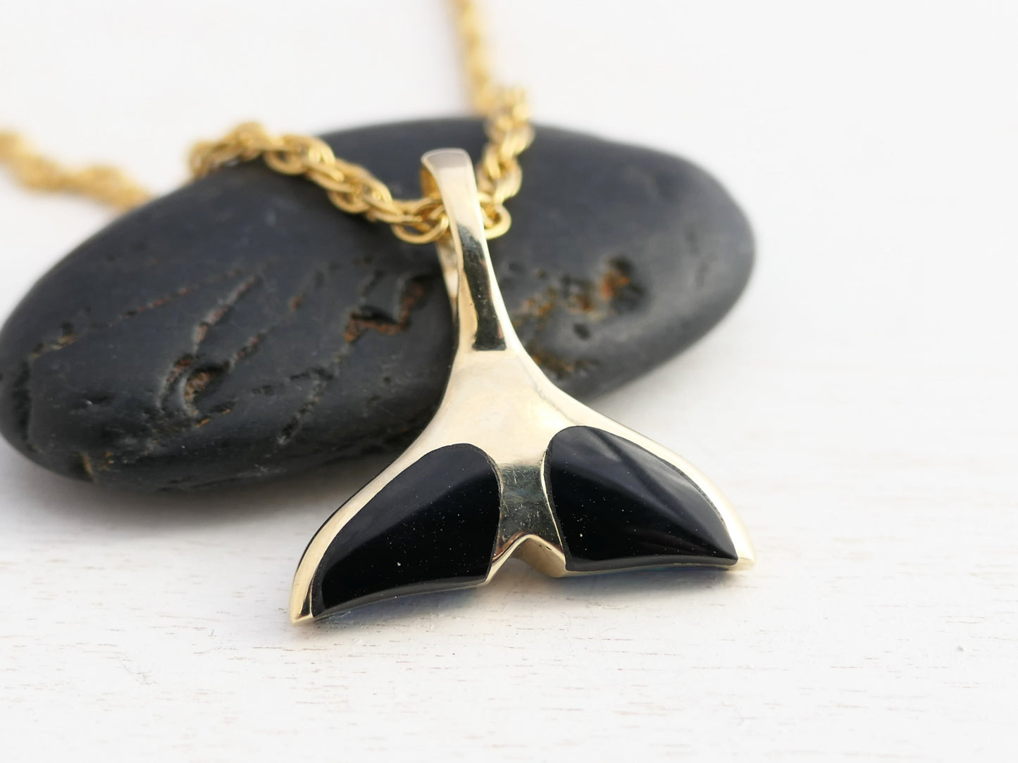 gold whale tail necklace with gemstones