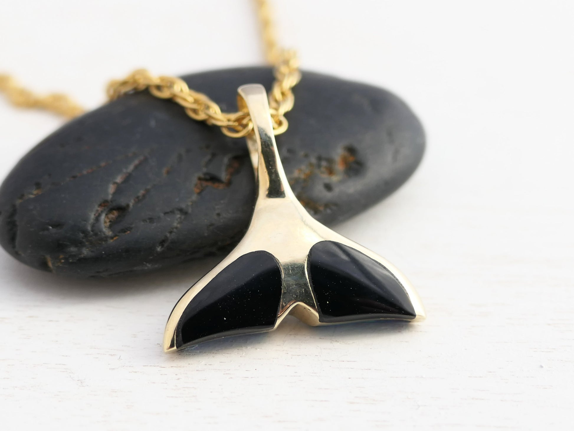 gold whale tail necklace with gemstones
