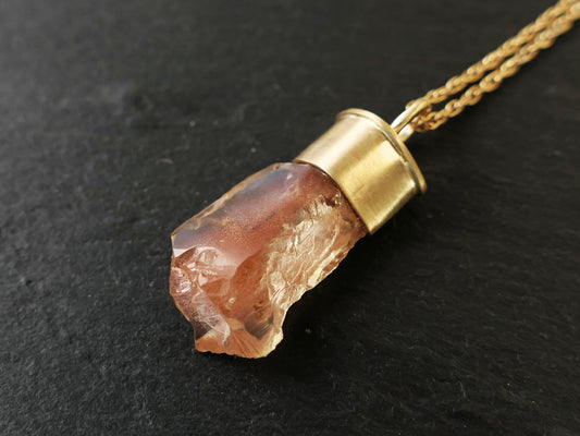 Raw Oregon sunstone pendant in 14k gold setting with peach schiller, on a gold-plated rope chain.