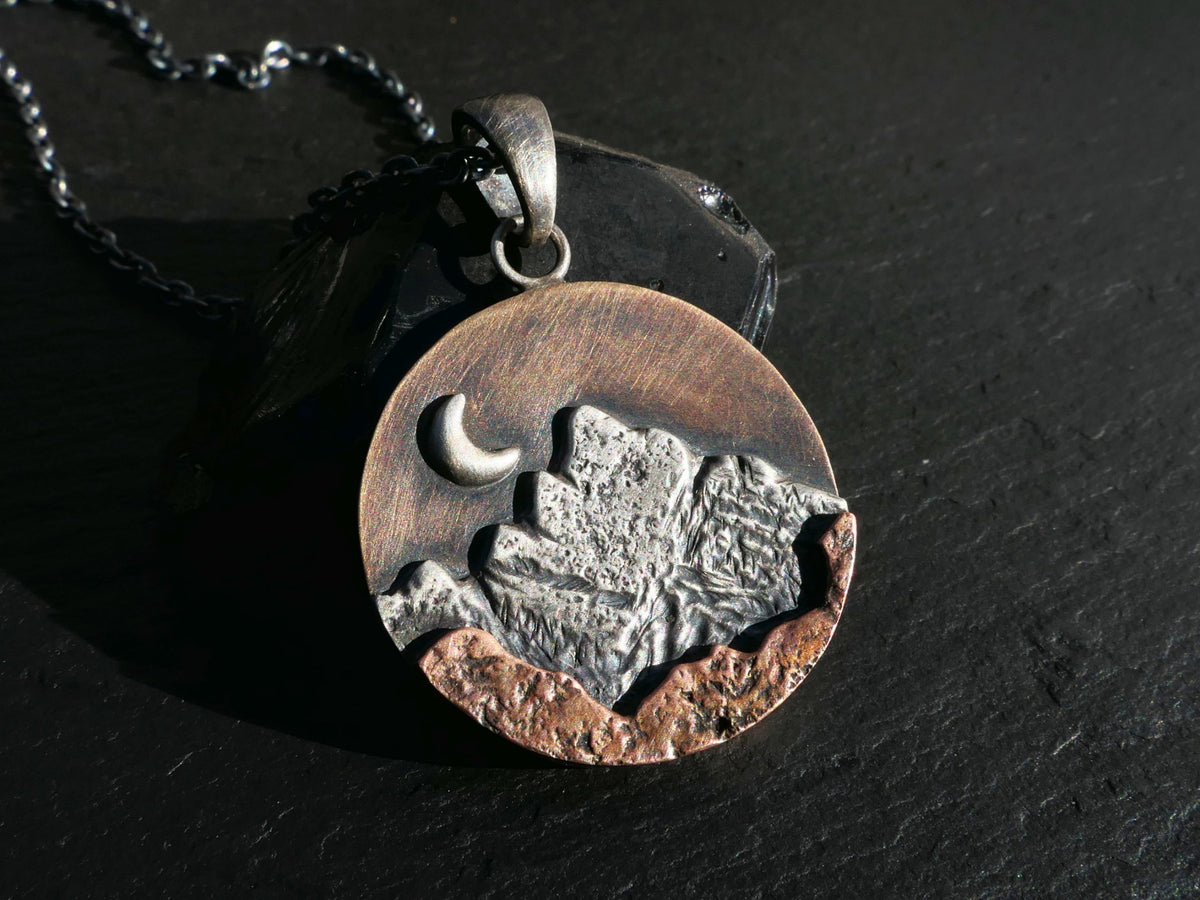 Rustic mountain pendant mixed metal necklace with sterling silver, bronze, and copper layers featuring a crescent moon and black sterling silver chain