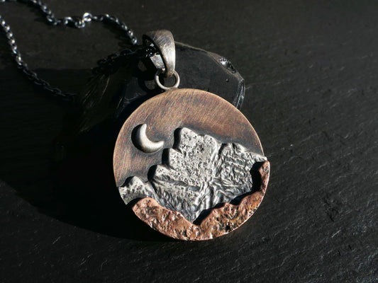 Rustic mountain pendant mixed metal necklace with sterling silver, bronze, and copper layers featuring a crescent moon and black sterling silver chain