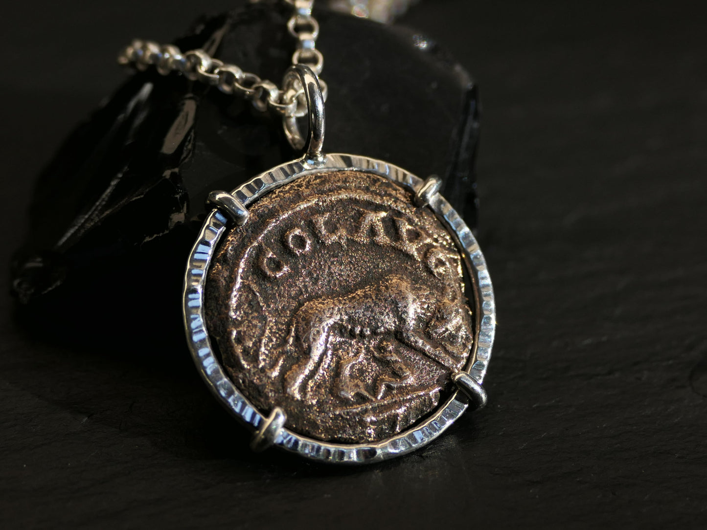 Ancient Gallienus she-wolf coin pendant in sterling silver, featuring the reverse depiction of a she-wolf, suckling twins, set in a four-prong sterling silver setting with a chain.