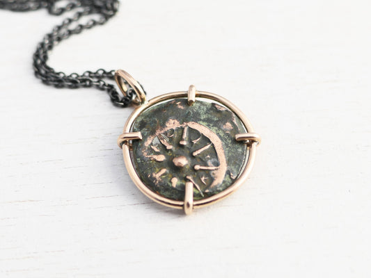 Authentic ancient Widows Mite coin pendant set in bronze with green and brown patina, 24mm length, displayed on a black background